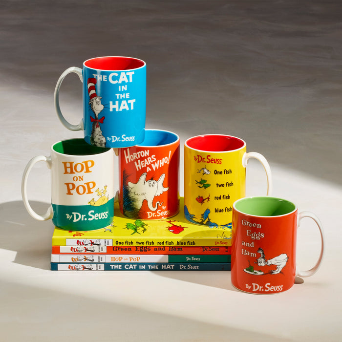 Set of Dr. Seuss-themed mugs and books on a gray background