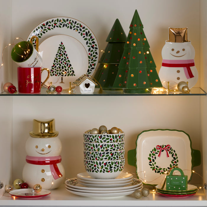 Decorative Christmas items including plates, mugs, and a snowman figure on a shelf.