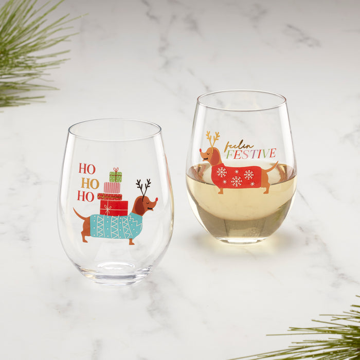 Two stemless wine glasses with festive designs on a marble surface.